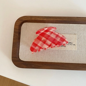 Vintage red plaid medium claw clip hair accessory for women on a stylish tray