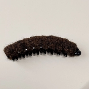 Dettaglio della clip a banana in peluche marrone con finta pelliccia per capelli