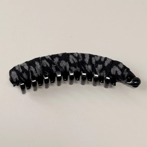 Dettaglio della clip a banana leopardata con texture in velluto e presa multi-dente sicura