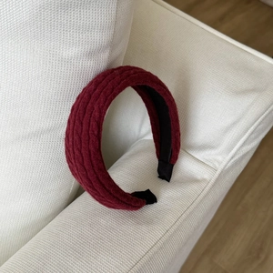 Détail d'un serre-tête tricoté bordeaux avec texture torsadée et doublure antidérapante douce