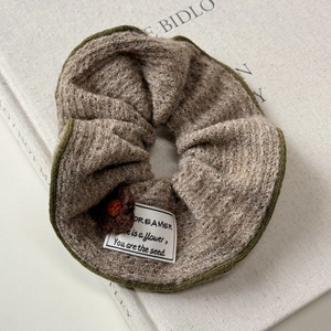 Retro knit hair scrunchie with leopard edge and brown crochet flower on fabric background