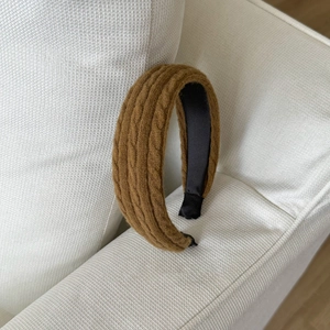 Détail de la texture torsadée en tricot marron et de la doublure en tissu noir du bandeau