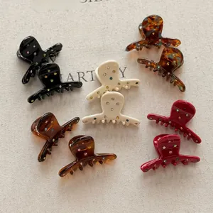 Macro detail of eight mini acetate hair claws with colorful rhinestone embellishments