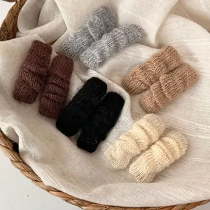 Winter thick knit leg warmers in various neutral colors shown in a rustic woven basket