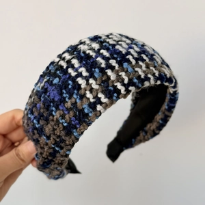 Detailaufnahme der mehrfarbigen dicken Tweed-Struktur auf einem gepolsterten Winter Stirnband