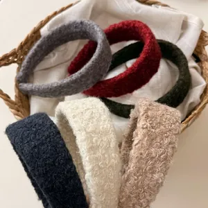 Thick plush winter headbands in six solid colors displayed in a rustic woven basket