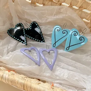 Retro heart-shaped Y2K hair clips set in black with rhinestones, blue, and purple lavender