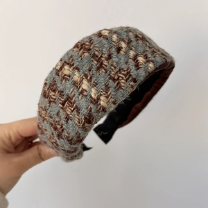 Detail eines dicken gepolsterten Haarreifs mit Chevron-Strickmuster in Grau und Braun