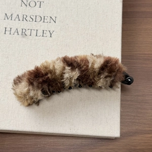 Détail de la pince banane en fausse fourrure pelucheuse marron et beige pour l'hiver