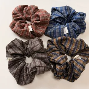 Set of four plaid fabric hair scrunchies featuring decorative Hand Made labels