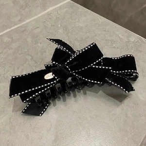 Elegant black velvet bow hair clip with white stitching and gold metal plate detail