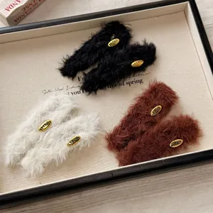 Plush faux fur headband set in black, cream, and brown with vintage gold oval metal plaques