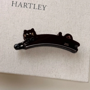 Detailed view of handmade cat-shaped acetate hair clip with sparkling rhinestone eyes