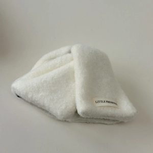 Détail du tissu peluche blanc doux et de l'étiquette tissée Little Freshness sur la pince