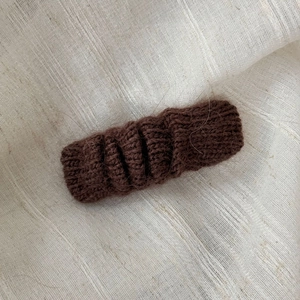 Detailed view of the soft knitted texture and plush dark brown fabric on the hair clip