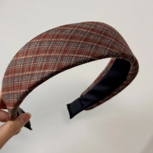 Detail of British style thick headband with brown plaid wool fabric texture for women