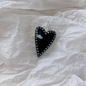 Detail of Y2K black heart hair clip with blue rhinestones and silver metal duckbill clip