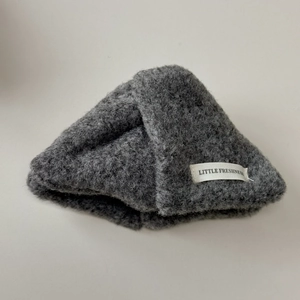 Détail du bonnet en tricot peluche gris foncé avec une étiquette logo blanche minimaliste