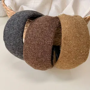 Lot de trois serre-têtes en mohair gris foncé, marron et jaune sur un panier