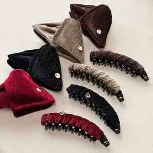 Detail of velvet banana clips in four colors with gold handmade metal tag for hair styling