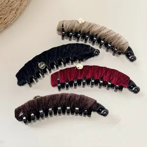 Detailed macro view of four velvet banana hair clips in dark colors with handmade gold charms