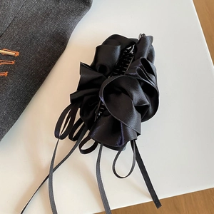 Makro-Detail der schwarzen Satin-Bananenspange mit elegantem Falten-Schleifendesign