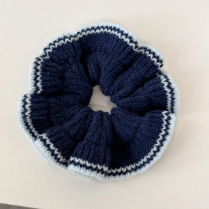 Gros plan détaillé du chouchou tricoté bleu foncé avec bordure contrastée bleue