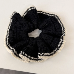 Détail de chouchou en tricot surdimensionné avec bordure texturée à rayures noir et blanc