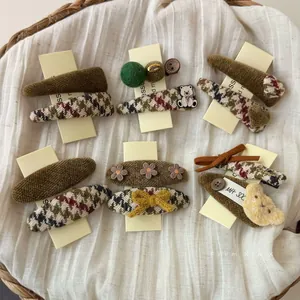 Detail shot of a vintage brown hair clip set featuring plush fabric and embroidery