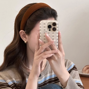 Close-up of orange velvet thick headband on model with elegant jewelry and cozy knitwear