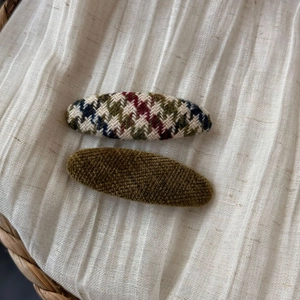 Close-up of retro knit hair clips with plaid patterns and olive green velvet texture