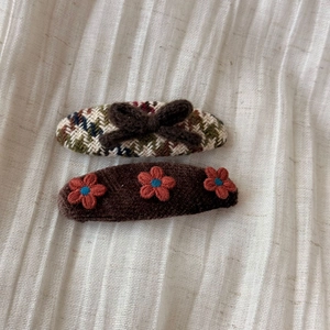Detail of vintage plaid hair clips and plush bows with knit floral patterns