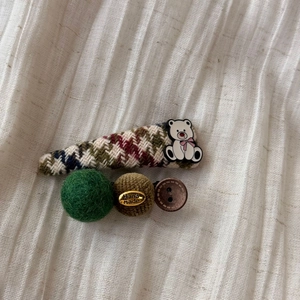 Detailed macro view of handmade plaid hair clips with bear and wool felt decorations