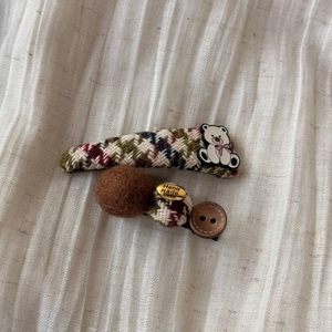 Detail of vintage plaid fabric hair clips with teddy bear and handmade metal tag