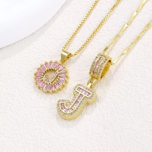 Luxurious gold-plated necklace set with pink zircon letter J pendants on marble background