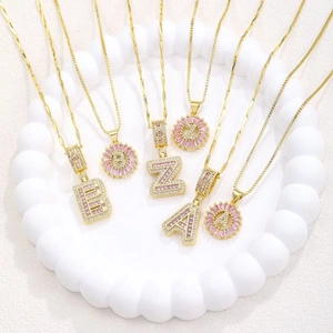 Luxury gold necklace set with pink crystal baguette gems and sparkling letter pendants