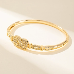 Bracelet jonc doré avec nœud élégant et cristaux pavés au style minimaliste chic