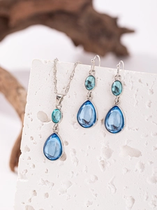Dettaglio del set collana e orecchini in cristallo blu a goccia vintage su pietra