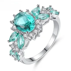 Detailed macro view of silver cluster ring featuring oval blue stone and white zircons