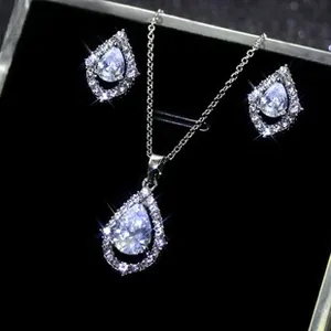 Macro shot of silver teardrop pendant necklace and stud earrings set with crystal stones