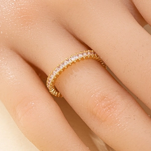 Macro shot of a gold-plated eternity ring with pavé-set zircons on a woman's finger