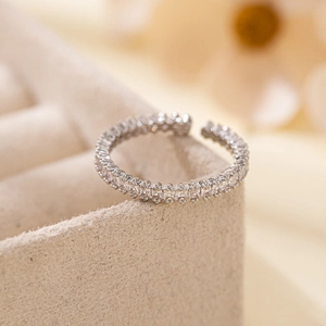 Elegant adjustable silver open ring with square-cut zircon stones on a jewelry box