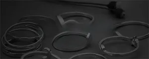 Collection of minimalist silver stainless steel hoop earrings and rings on dark background