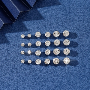 Ensemble de boucles d'oreilles en zircon avec cristaux ronds sur fond bleu texturé