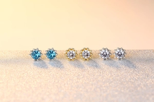 Détail de trois paires de boucles d'oreilles en zircone bleues et blanches serties couronne