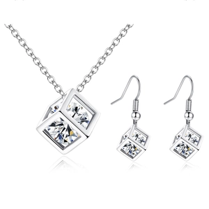 Close-up of cube pendant necklace and matching drop earrings with zircon inlays