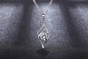 Macro detail of silver angel wing pendant with brilliant round zircon and elegant rope chain