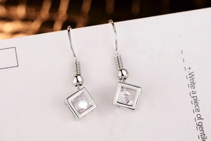 Detail view of cube zircon drop earrings with s925 silver finish on white elegant card