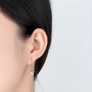 Minimalist silver geometric hook earrings with square zircon stone worn by a model