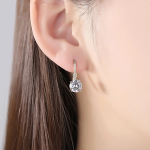 Boucles d'oreilles dorées avec zircons ronds sur modèle au style luxueux minimaliste
